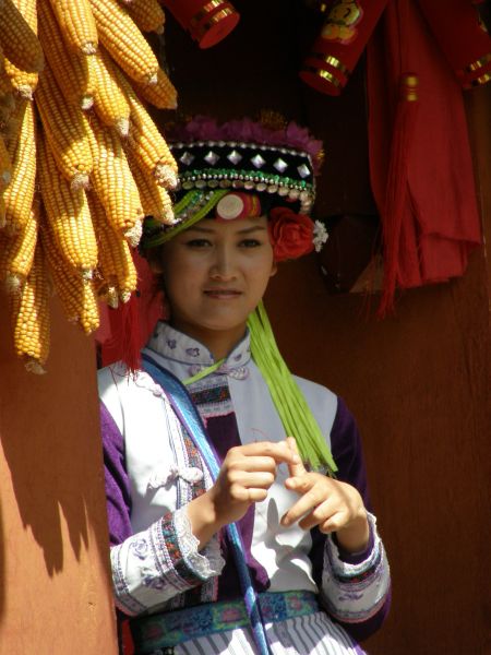 Представительница одной из местных народностей у входа в традиционное жилище. 23.02.2010, г. Куньмин (пров. Юньнань, КНР).